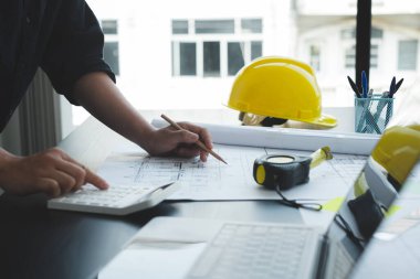 İnşaatta çalışan mimarlar ya da mühendisler inşaat planları, baskı, inşaat sahalarında yazılar çiziyor. Ev tasarımı kavramı.