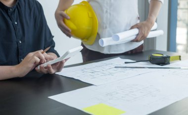 Mühendisler ve mimarlardan oluşan bir ekip, çalışma ekibi, toplantı, inşaat planları ve çizim planları, baskı, inşaat alanlarında yazma konuları. Ev tasarımı kavramı.