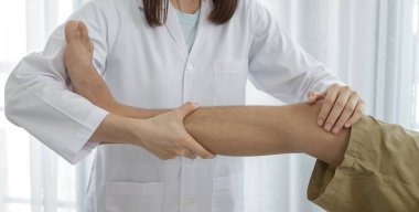 Erkek hastalar rehabilitasyon merkezlerinde muayene ve tedavi için diz ağrısı olan fizyoterapistlere danıştılar. Rehabilitasyon fizyoterapi konsepti.