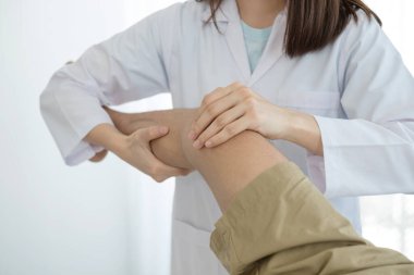Erkek hastalar rehabilitasyon merkezlerinde muayene ve tedavi için diz ağrısı olan fizyoterapistlere danıştılar. Rehabilitasyon fizyoterapi konsepti.
