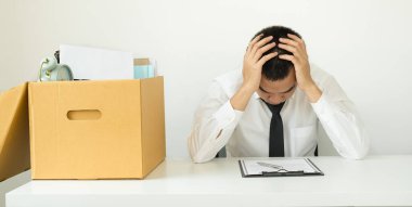 Bir erkek ofis çalışanı, karton kutulara bir şeyler dolduran bir şirketten kovulmaktan memnun değildir. Genç adam kovulduğu için stresliydi ve hayal kırıklığına uğradı. İşten çıkarma ve işsizlik kavramı.