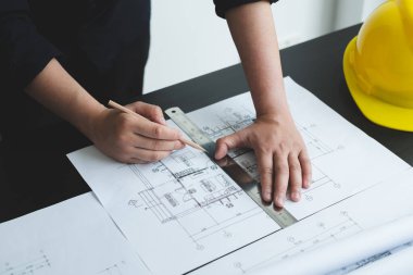 İnşaatta çalışan mimarlar ya da mühendisler inşaat planları, baskı, inşaat sahalarında yazılar çiziyor. Ev tasarımı kavramı.