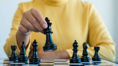 Hareket eden iş kadını eli, rekabetteki satranç liderlik, takipçiler ve ticari başarı stratejilerini gösteriyor.
