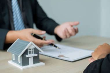 House modelli bir emlakçı ev sigortası almak için müşterilerle konuşuyor. Ev sigortası kavramı.