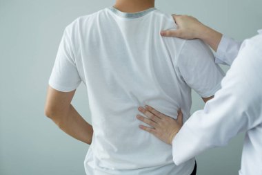 Kadın fizyoterapistler, rehabilitasyon merkezinde sırt masajı ve kas iyileşmesi için erkek hastalara fiziksel yardım sağlıyorlar..