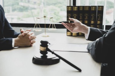 Bir erkek avukat ya da bir yargıç müvekkillerine yargı adaleti ve kovuşturma hakkında ölçekli danışmanlık yapıyor..