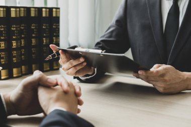 Bir erkek avukat ya da bir yargıç müvekkillerine yargı adaleti ve kovuşturma hakkında ölçekli danışmanlık yapıyor..