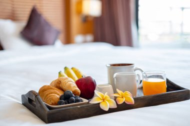 Meyveye odaklan. Meyveli bir otel odasında, VIP misafirlerin gelişini karşılamak için yatağın üzerine bir tepsi koyun..