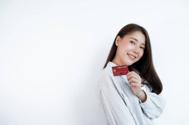 Kredi kartı tutan Asyalı bir kadının eli online alışveriş ve internet ödemeleri için kullanılır..