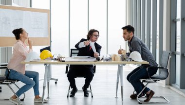 Erkek ve kadın mühendisler ve mimarlardan oluşan bir ekip, çalışma ekibi, inşaat planlarını tartışıyor ve çiziyor, baskı yapıyor, inşaat alanlarında yazıyor..