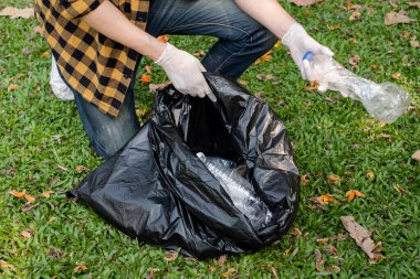 Adamın elleri plastik şişeleri topluyor, çöpleri siyah çöp torbalarına doldurup parkları temizliyor, kirlilikten kaçınıyor, çevreye ve ekosisteme dost oluyor..