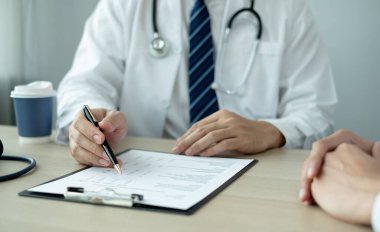 Erkek doktorlar, bir kadın hasta bir doktorla tanışıp hastalık sorunlarıyla ilgili sonuçlar aldıktan sonra tedavi öneriyor. Tıbbi ve sağlık hizmetleri kavramları.