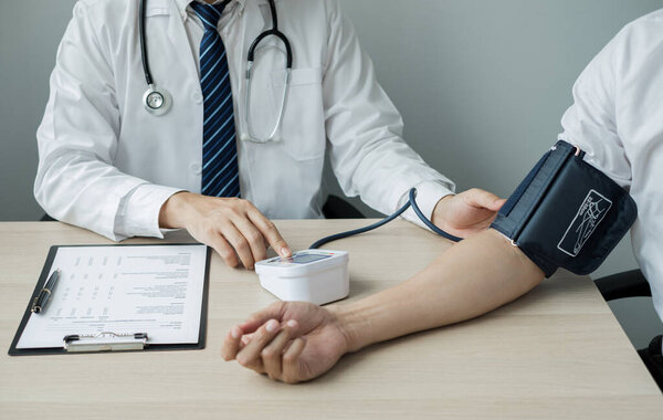 Man doctors measured blood pressure, the patient examined the heartbeat, and talked about health care closely. Medical and health care concepts.