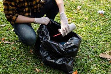 Adamın elleri plastik şişeleri topluyor, çöpleri siyah çöp torbalarına doldurup parkları temizliyor, kirlilikten kaçınıyor, çevreye ve ekosisteme dost oluyor..