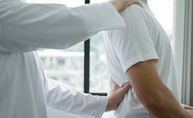 Kadın fizyoterapistler, rehabilitasyon merkezinde sırt masajı ve kas iyileşmesi için erkek hastalara fiziksel yardım sağlıyorlar..