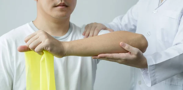 Γυναίκες Φυσικοθεραπευτές Βοηθούν Άνδρες Ασθενείς Τραυματισμούς Στα Χέρια Τράβηγμα Των — Φωτογραφία Αρχείου