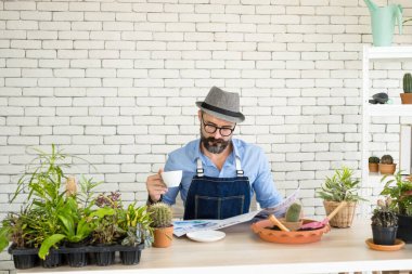 Bıyıklı, yaşlı ve yakışıklı bir adam ağaç bakımıyla mutlu olur. Evde bahçıvanlık hobisi. Emeklilikten sonra mutlu yaşamak. Doğa ve çevre kavramları.