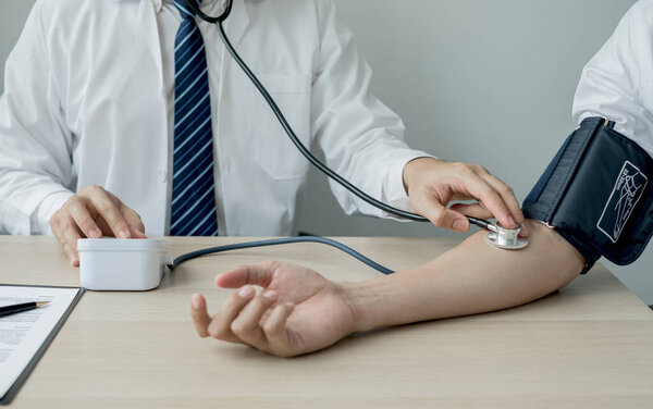 Man doctors measured blood pressure, the patient examined the heartbeat, and talked about health care closely. Medical and health care concepts.