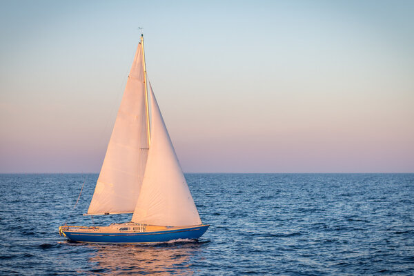blue sailboat in the ocean
