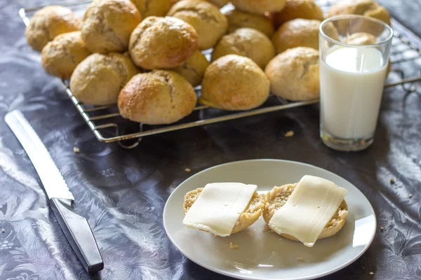Pan y bollos horneados con queso y vaso de leche Imágenes de stock libres de derechos