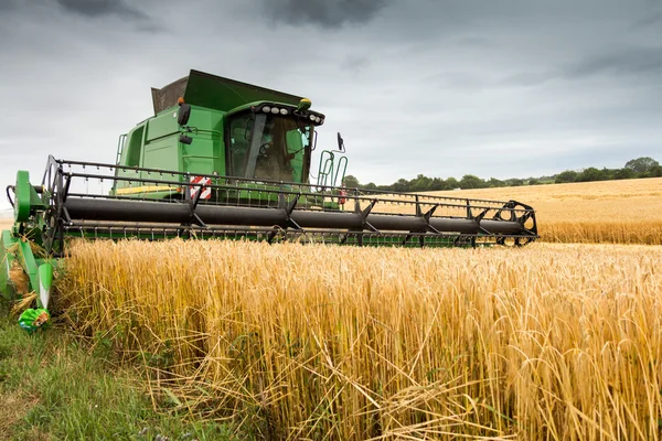 Combine harvester at work harvesting field of crop — Stock Photo, Image