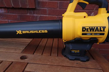 EXETER, DEVON, ENGLAND - 23 Eylül 2020: Dewalt 18 voltluk kablosuz yaprak üfleyici kullanılmaya hazır bir bahçe masasında dinleniyor
