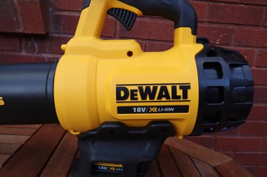 EXETER, DEVON, ENGLAND - 23 Eylül 2020: Dewalt 18 voltluk kablosuz yaprak üfleyici kullanılmaya hazır bir bahçe masasında dinleniyor