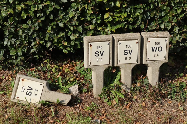 Four Concrete Signs Roadside Sluice Valve Washout Hydrant One Broken — Stock Photo, Image
