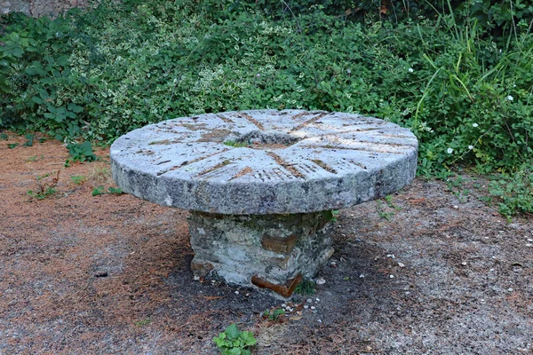 A circular pedestal picnic table made from bricks in a small public park in the town of Colyton in Devon.