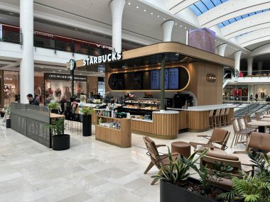 Pamplona, İspanya - 23 Şubat 2026 - Modern bir alışveriş merkezinde bulunan bir Starbucks kahvecisi. Binanın güncel tasarımı hafif ahşap paneller, sıcak ışıklandırma ve içecek, kahve ve hamur işleri sergilenen merkezi bir bar..