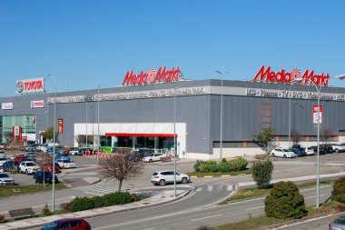Pamplona, İspanya - 23 Şubat 2026. Binanın tepesinde MediaMarkt tabelası olan büyük bir mağaza. Bina gri metal cepheli, kırmızı detaylarla dolu bir ana girişi ve çok sayıda aracı olan bir otoparkı var.,