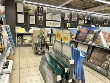 Pamplona, İspanya - 28 Şubat 2026. Bir Conforama ev dekorasyonu mağazası. Dekoratif tablolar, sanat tuvalleri, aynalar, farklı tarz ve boyutlarda çerçeveler sergilenen raflar ve duvar panelleriyle dolu bir koridor var. Resimlerde modern tasarımlar yer alıyor.,