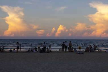 Da Nang, Vietnam 7 Temmuz 2024: İnsanlar Vietnam 'ın ortasındaki yeni tatil beldesi Da Nang' ın günbatımının altında benim kumsalımda su oynuyorlar.