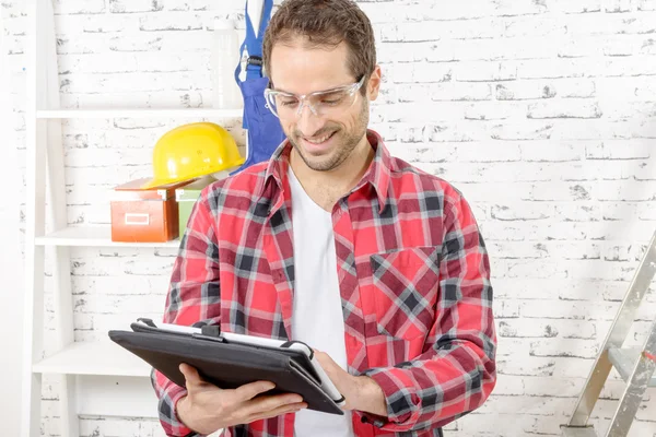 Atractivo joven usando la tableta para bricolaje — Foto de Stock