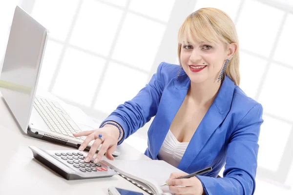Attraktive blonde Sekretärin sitzt an ihrem Schreibtisch — Stockfoto