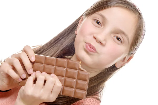 Preteen menina come chocolate, isolado em branco — Fotografia de Stock
