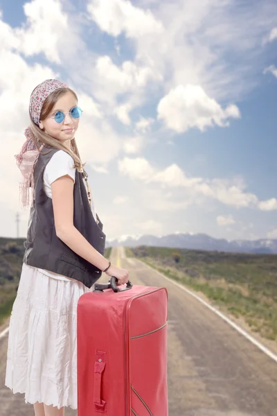 Young girl on road with vintage clothes and suitcase — Stock Photo, Image