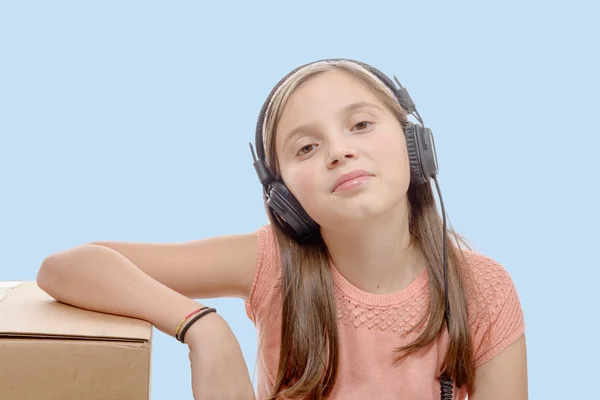 Preadolescente escuchando música con auriculares, fondo azul —  Fotos de Stock