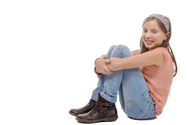 Mladé dospívající sedí na podlaze na bílém pozadí — Stock fotografie
