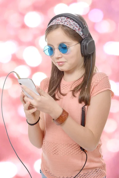 Preteen girl listening to music with his smartphone, bokeh backg — Stock Photo, Image