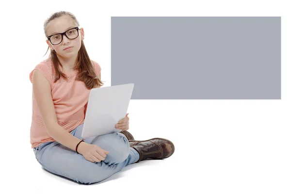 Beautiful preteen girl with a tablet computer. — Stock Photo, Image