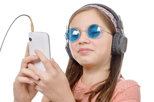 Niña preadolescente escuchando música con su teléfono inteligente, en blanco —  Fotos de Stock