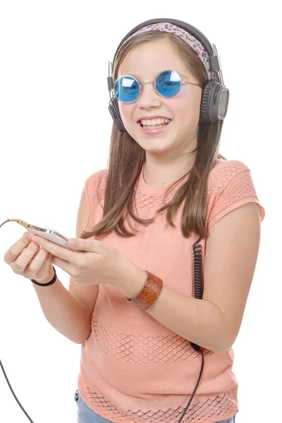 Дошкольница слушает музыку со смартфона на белом — стоковое фото