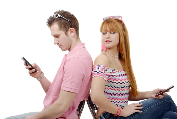 Young couple talking on mobile phones sitting back to back. — Stock Photo, Image