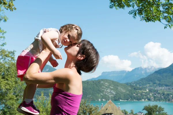Beautiful mom is a hug to her daughter in nature — Stock Photo, Image