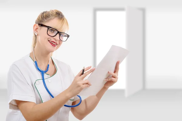 Ładne kobiece kobieta lekarz pisania jej rozpoznania w szpitalu — Zdjęcie stockowe