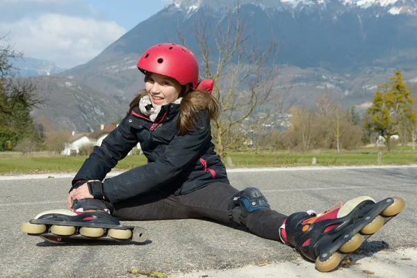 Preteen flicka i rullskridsko sitter på vägen — Stockfoto