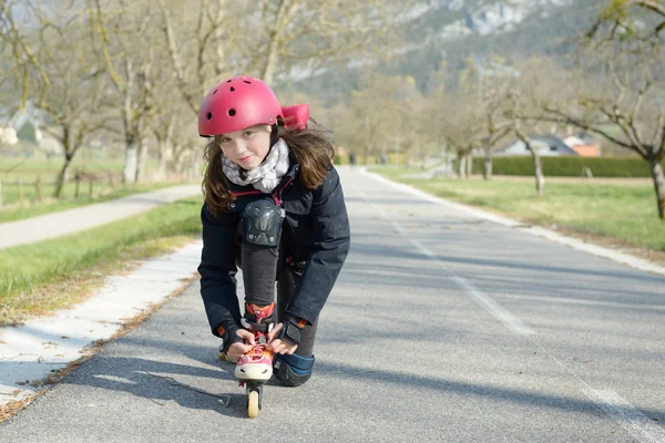 トラックでヘルメットにローラー スケートでかなりプレティーンの女の子 — ストック写真