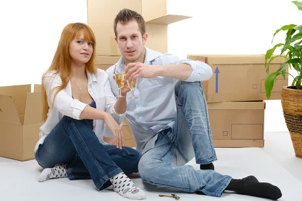 couple celebrating their new home, keys and champagne in hand.