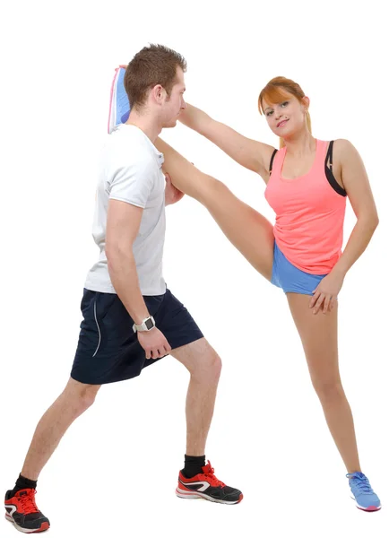 Beautiful young woman and man doing stretching exercises — Stock Photo, Image